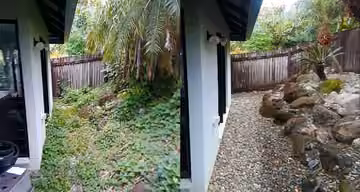 Before and after photos of an overgrown side garden cleared