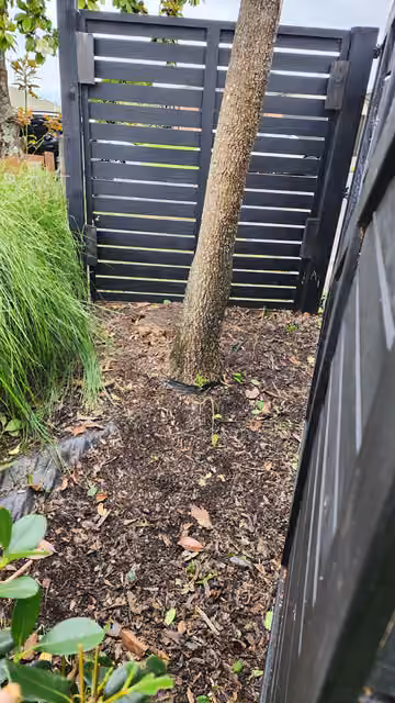 Customer photo of a cleared garden path beside a fence